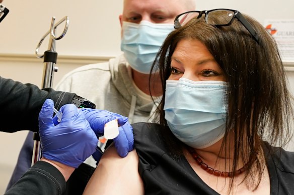 Keri Wegg receives her second COVID-19 vaccine shot as husband Rodney watches at IU Health North Hospital in Carmel, Indiana. 