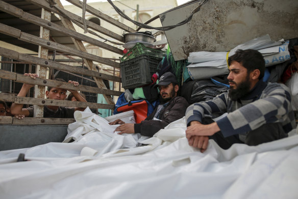 Palestinians mourn over the bodies of relatives killed by the Israeli airstrike, at a morgue in Rafah.