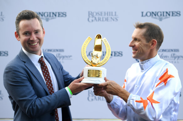 Hugh Bowman holds the Golden Slipper trophy with co-trainer Adrian Bott after Farnan's win on Saturday.