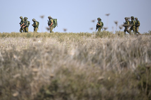 Israel Defense Forces soldiers march through a field near an artillery position on October 11, 2023 in Netivot, Israel.