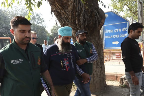 Police escort Rajwinder Singh, 38, after he was arrested in New Delhi, India, in November 2022.