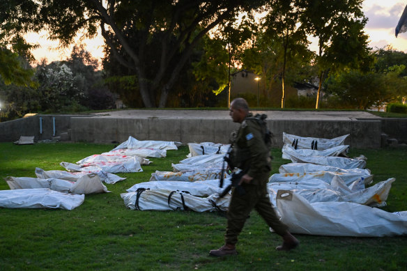  An Israeli Defence Force soldier walks past body bags of over 20 dead Hamas militants with the word “terrorist” written in Hebrew.