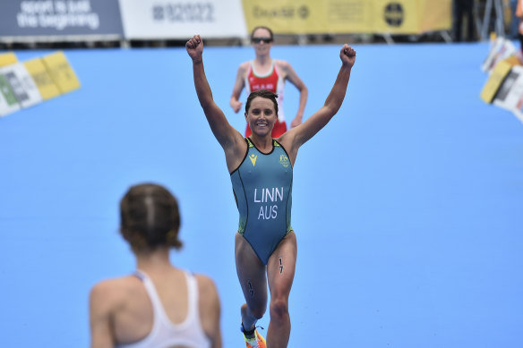 Sophie Linn of Australia raises her arms after completing the women’s individual triathlon.
