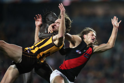Essendon’s Archie Perkins takes down Jack Scrimshaw of the Hawks.