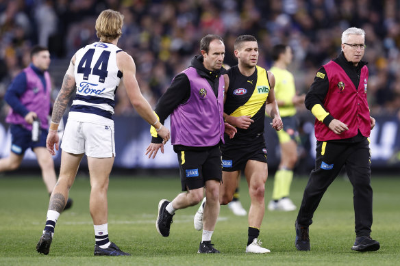 Dion Prestia is helped from the field in the clash against the Cats.
