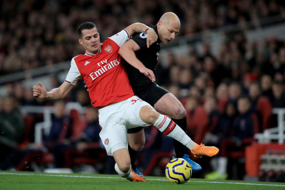 Arsenal's Granit Xhaka tussles with Brighton's Aaron Mooy.