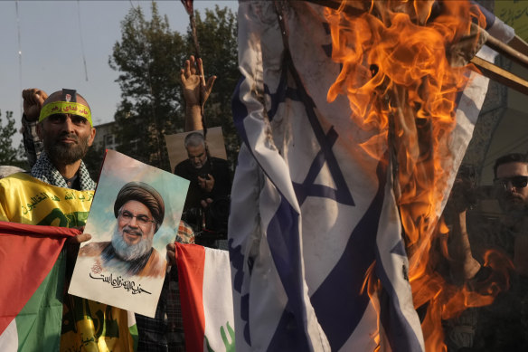 An Iranian demonstrator holds a poster of slain Hezbollah leader Hassan Nasrallah during a rally in Tehran, Iran, on Tuesday.