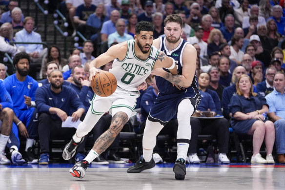 Boston Celtics forward Jayson Tatum, left, drives against Dallas Mavericks guard Luka Doncic.