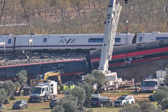 Venerdì una gru opera sul luogo del disastro di vagoni ferroviari in Spagna.