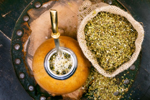 Yerba mate in a traditional calabash gourd and bag of dry herb.