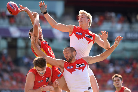 Isaac Heeney attacks the pack against Gold Coast with his recently-broken right hand covered by a protective glove.