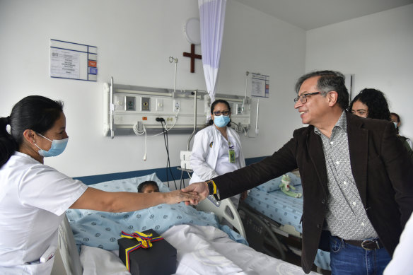 Colombia’s President, Gustavo Petro, greets a nurse tending to one of the four children at a military hospital in Bogota, Colombia.