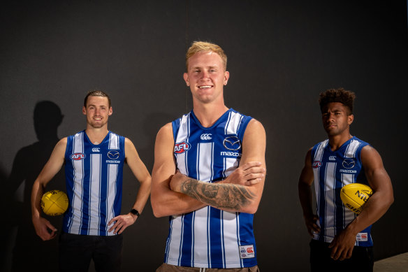 Jaidyn Stephenson and Atu Bosenavulagi sporting their new North Melbourne colours on Monday, along with Lachie Young.