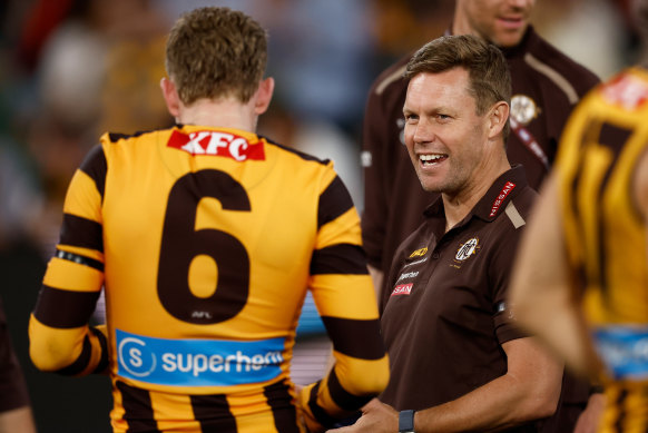 Hawks coach Sam Mitchell has a laugh with skipper James Sicily on a big night for their club at the MCG.