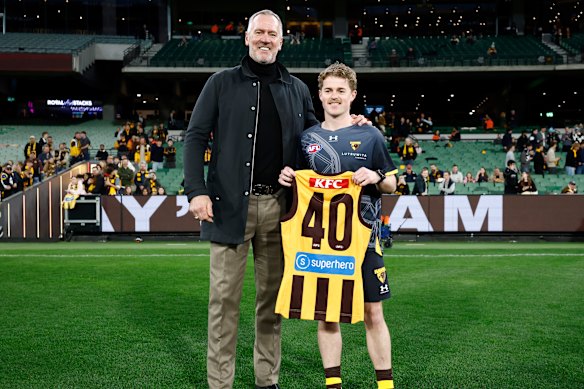Debutant Max Beattie of the Hawks is presented with his jumper by Paul Salmon.