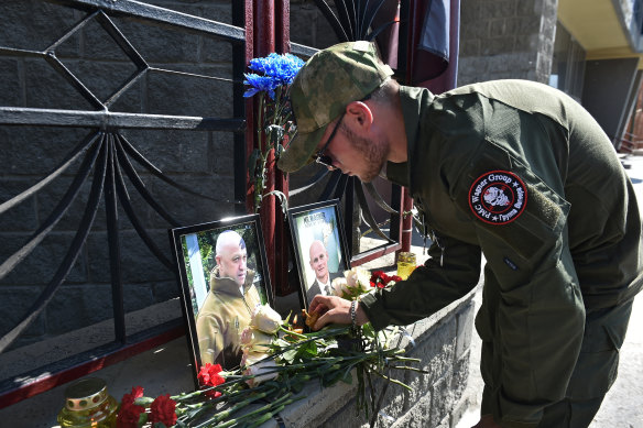 A Wagner mercenary with portraits of Wagner boss Yevgeny Prigozhin and commander Dmitry Utkin at a memorial that sprung up outside a Wagner office in Novosibirsk.