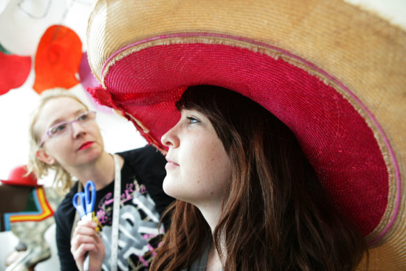 Making the final adjustments to a hat in more buoyant times, before the Melbourne Cup.