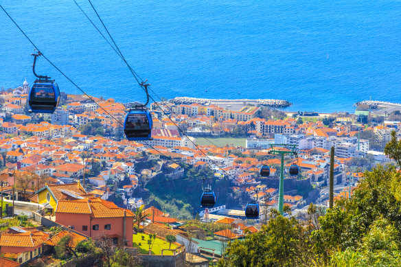 Cable cars transporting tourists above Funchal city in Madeira.