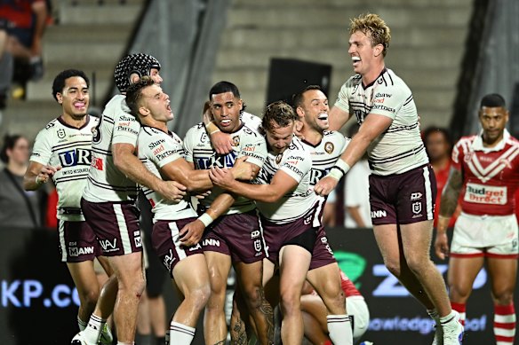 Manly players celebrate a try in their big win over the Dolphins in Brisbane on Thursday night.