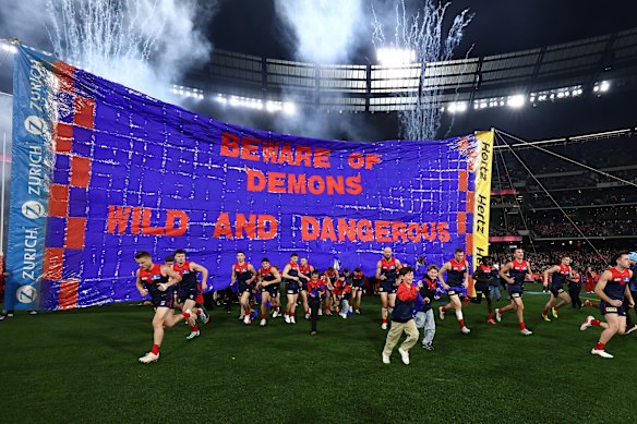 Melbourne run through their banner.