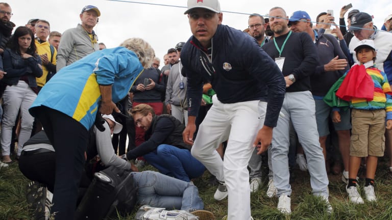 Brooks Koepka checks on the fan he hit with a tee shot and gives her a signed glove.