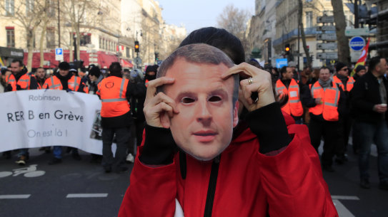 A protester holds a mask of French President Emmanuel Macron during a demonstration in Paris on Friday.