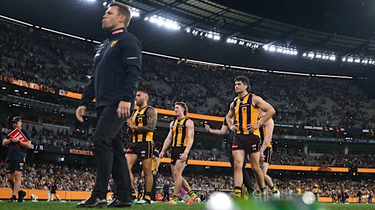 Poor look: Sam Mitchell and his Hawks leave the MCG after can and bottles had been flung on to the ground.