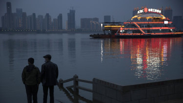 Residents chat along the Yangtze River in Wuhan in central China's Hubei province on Sunday. Quarantine in the the epicentre of China's coronavirus outbreak is to be formally lifted on Wednesday.