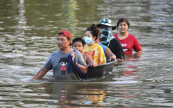 Thai people wade through floodwaters in Chaiyaphum province, north-east of Bangkok, on Tuesday.