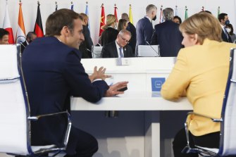 On the sidelines of the G20 summit in Rome, Macron French President Emmanuel Macron, left, tells reporters Prime Minister Scott Morrison, middle, lied to him over the cancellation of the submarine contract. 