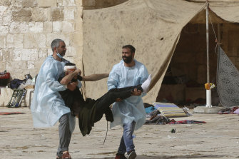 A wounded man is evacuated during clashes at the al-Aqsa Mosque compound.
