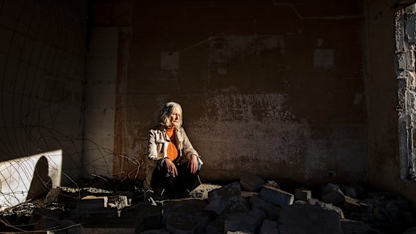 Six months after the fires, Jann Gilbert sits in the ruins of her Mallacoota home.