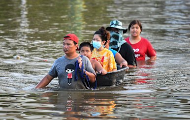 Thai people wade through floodwaters in Chaiyaphum province, north-east of Bangkok, on Tuesday.