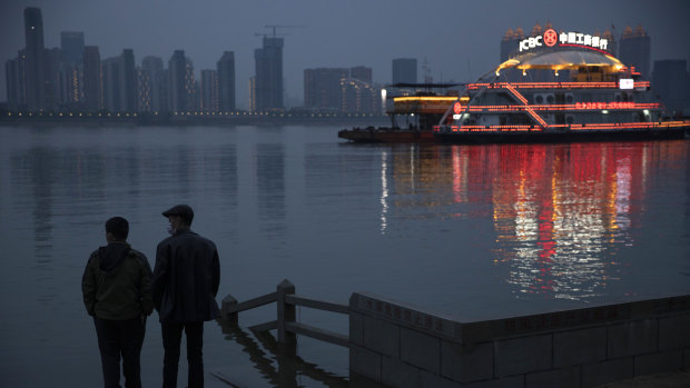 Residents chat along the Yangtze River in Wuhan in central China's Hubei province on Sunday. Quarantine in the the epicentre of China's coronavirus outbreak is to be formally lifted on Wednesday.