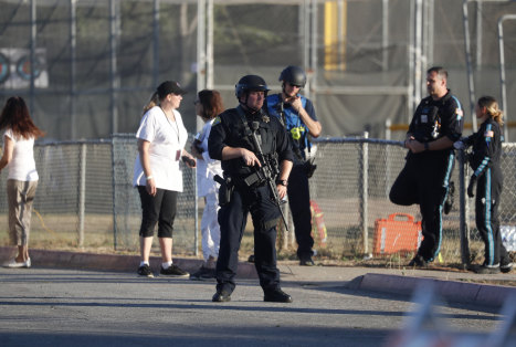 A police officer stands guard at Gilroy High School after a deadly shooting at the Gilroy Garlic Festival.