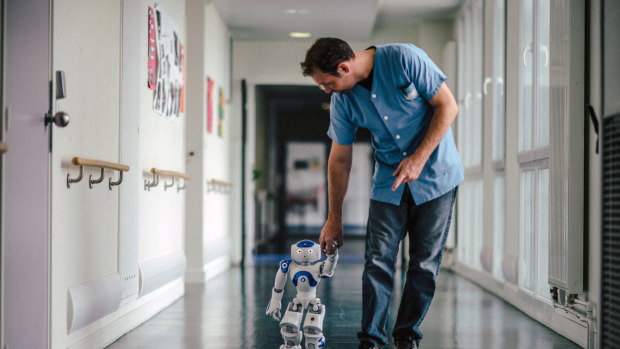 Mickael Feret, a nurse, walks with a robot named Zora at Jouarre, a nursing facility an hour outside Paris.