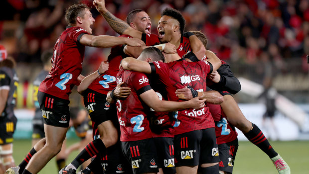 George Bridge, Bryn Hall and Leicester Fainga’anuku of the Crusaders celebrate  after the final whistle.