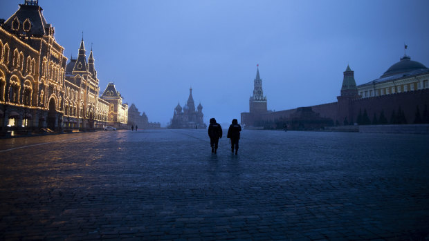 Two police officers patrol an almost empty Red Square.