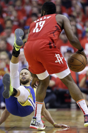 Golden State star Stephen Curry, left, hits the boards after a bump from Rockets guard James Harden.
