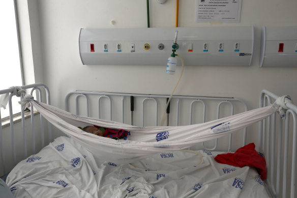 A Yanomami baby lies in a hammock  in a children’s hospital in Roraima, Brazil, on Thursday. The government declared a public health emergency for the Yanomami people in the Amazon, who are suffering from malnutrition and diseases such as malaria as a consequence of illegal mining. 