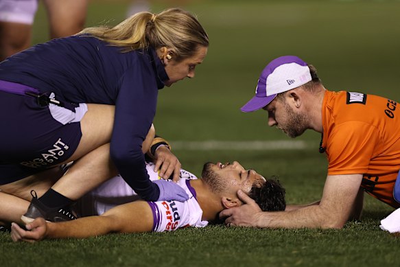 Siulagi Tuimalatu-Brown of the Storm is treated by medical staff after a high shot from Sharks centre Michael Gabrael.