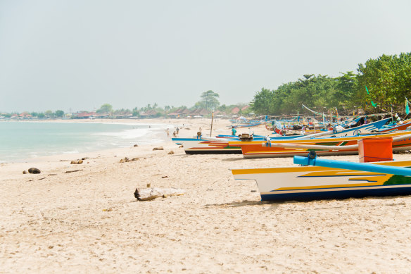 Fishing boats with painted prows line
Jimbaran beach.