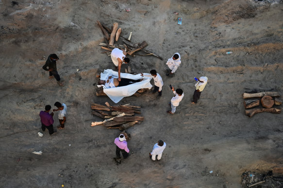 Relatives perform the last rites for the cremation of a man who died after contracting Covid-19 on the banks of the Ganges river in Allahabad, Uttar Pradesh, India.