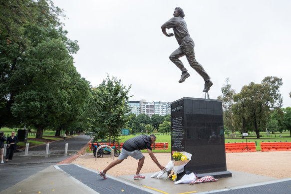 Cricket fans pay tribute at the statue of Shane Warne.