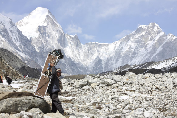 A porter carries crates containing oxygen tanks on his way towards Everest Base Camp.