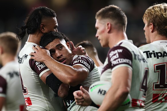 Tolutau Koula celebrates scoring a try.