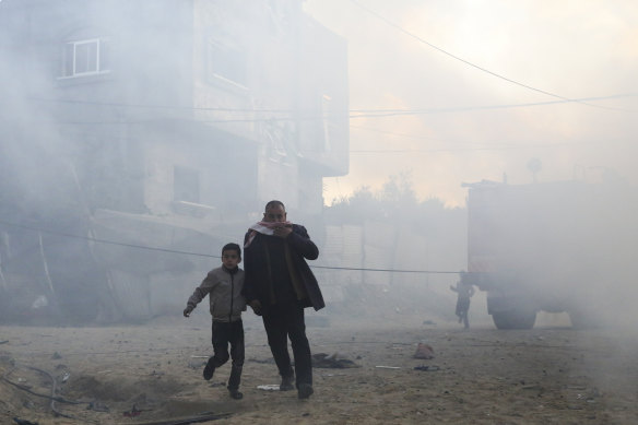 Palestinians flee after an Israeli strike on a residential building in Rafah on Monday.