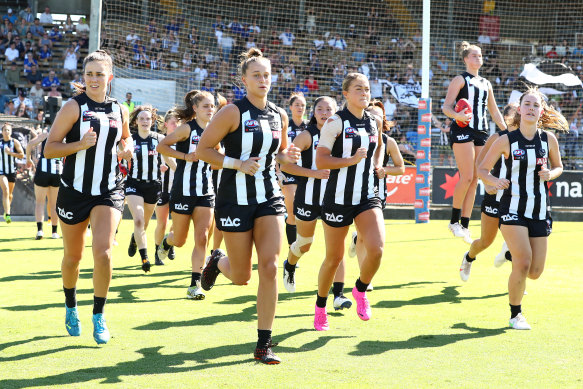 Chloe Molloy of the Magpies and Ruby Schleicher of the Magpies run out with team mates during the 2021 AFLW Finals Series match between the Collingwood Magpies and the North Melbourne Kangaroos.