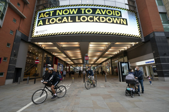 A sign in central Manchester urges people to act now to prevent the spread of COVID-19 as cases surge.