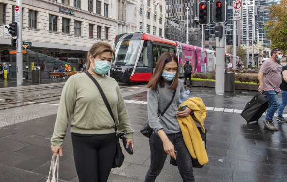 People wearing face masks in Sydney’s CBD, after the NSW government introduced new restrictions on Thursday.